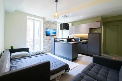 a living room with a couch and a kitchen at Spacieux et Moderne T2 - Hyper Centre in Nice