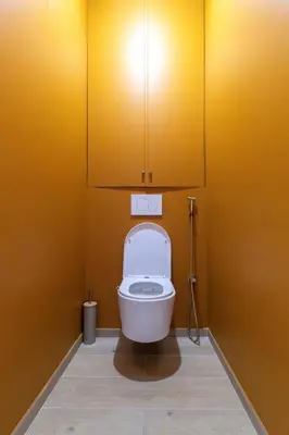 a bathroom with a toilet with a yellow wall at Le charme de l'ancien, rénové - Nice - 4 personnes in Nice