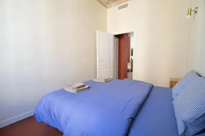 a blue bed with two towels on top of it at Le charme de l'ancien, rénové - Nice - 4 personnes in Nice