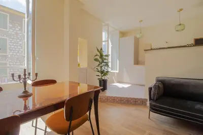 a dining room with a glass table and a couch at Le charme de l'ancien, rénové - Nice - 4 personnes in Nice