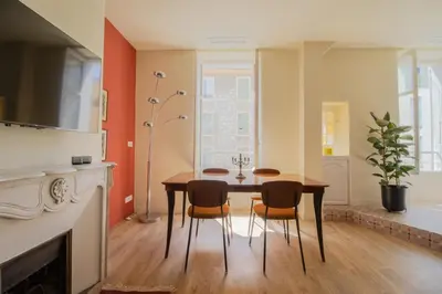 a living room with a dining room table and chairs at Le charme de l'ancien, rénové - Nice - 4 personnes in Nice