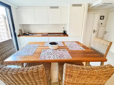 a kitchen with a wooden table and chairs at Green Heaven Apt, Rickeys in Cap d'Ail