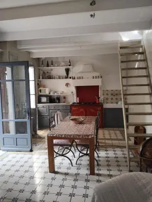 a kitchen with a table and a staircase in a room at Maison authentique in Nice