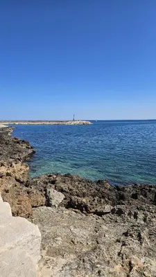 a large body of water with rocks and the ocean at Maison authentique in Nice