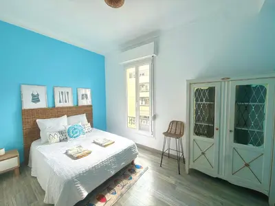 a bedroom with blue walls and a bed and a chair at La Baieta - Typical Nice Apartment in Nice