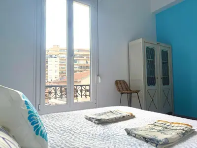 a bedroom with a bed and a large window at La Baieta - Typical Nice Apartment in Nice