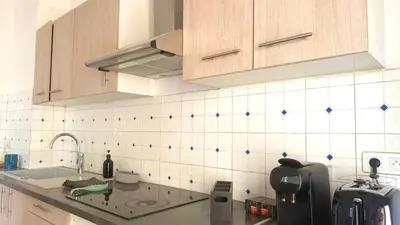 a kitchen with white and blue tiles on the wall at La Baieta - Typical Nice Apartment in Nice