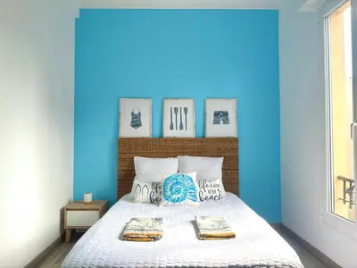 a blue bedroom with a bed with two towels on it at La Baieta - Typical Nice Apartment in Nice
