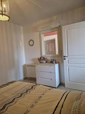 a bedroom with a bed and a dresser and a mirror at Appartement 2 P calme in Cagnes-sur-Mer