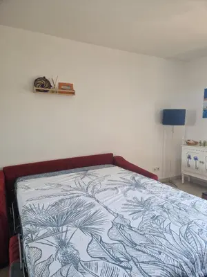 a bedroom with a bed with a blue and white blanket at Appartement 2 P calme in Cagnes-sur-Mer
