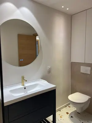 a bathroom with a sink and a toilet and a mirror at Appartement Duplex Bord de Mer in Cagnes-sur-Mer