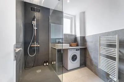 a bathroom with a shower and a washing machine at Nice Renting - 35 Massena - Architect Flat Ultimate Charm Massena Center in Nice