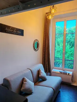 a living room with a couch and a large window at Cosy Mezzanine Studio - Nice Notre Dame - 10 min Promenade in Nice