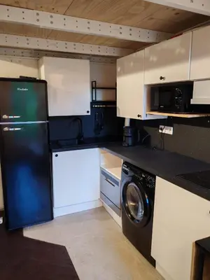 a kitchen with white cabinets and a washing machine in it at Cosy Mezzanine Studio - Nice Notre Dame - 10 min Promenade in Nice