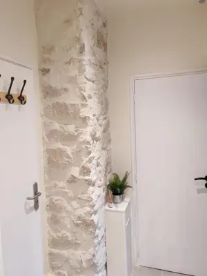 a hallway with a stone wall next to a door at Cosy Mezzanine Studio - Nice Notre Dame - 10 min Promenade in Nice