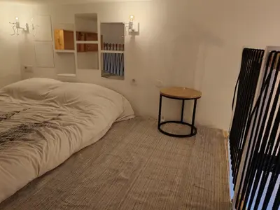 a small bedroom with a bed and a table at Cosy Mezzanine Studio - Nice Notre Dame - 10 min Promenade in Nice