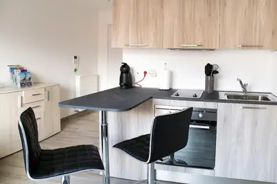 a kitchen with a counter and two chairs and a sink at Studio climatisé au calme, mezzanine et balcon in Nice