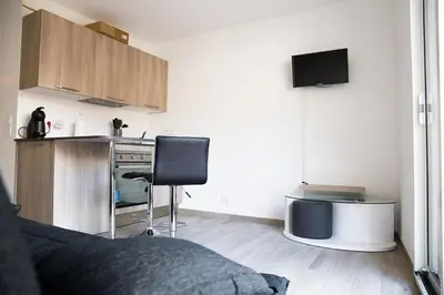 a living room with a bed and a kitchen at Studio climatisé au calme, mezzanine et balcon in Nice