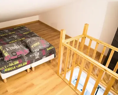 a small bedroom with a bed and a staircase at Studio climatisé au calme, mezzanine et balcon in Nice
