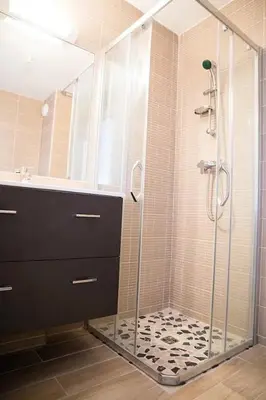 a shower with a glass door in a bathroom at Studio climatisé au calme, mezzanine et balcon in Nice