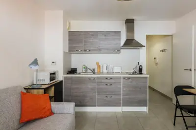 a living room with a couch and a kitchen at Studio au port de nice in Nice