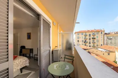 a room with a balcony with a bed and a table at Studio au port de nice in Nice