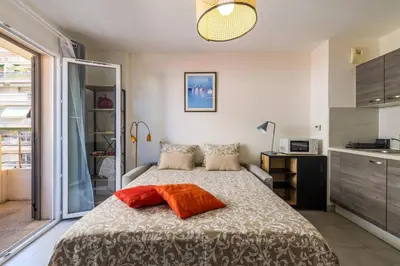 a bedroom with a bed and a kitchen at Studio au port de nice in Nice