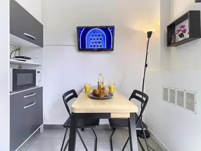 a small kitchen with a table with a plate of food on it at Hyper Center - Superb Studio - Cozy - Wifi in Nice