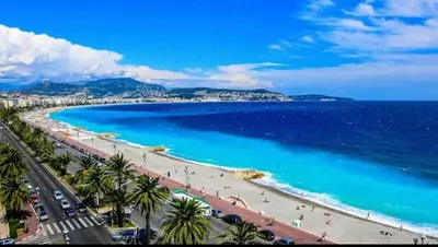 a view of a beach with palm trees and the ocean at Hyper Center - Superb Studio - Cozy - Wifi in Nice