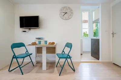 two chairs in a room with a table and a clock at Blue Escape Nice in Nice