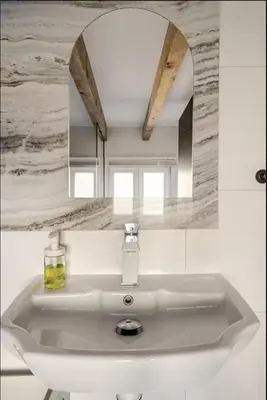 a white sink with a mirror above it at Séjour de luxe sur les collines niçoises in Nice