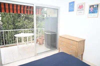 a room with a balcony with a table and a dresser at Beautiful 3-room apartment with terrace in Nice