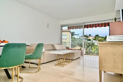 a living room with a couch and a table and chairs at Beautiful 3-room apartment with terrace in Nice