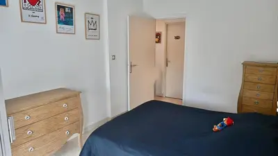 a bedroom with a blue bed and a wooden dresser at Beautiful 3-room apartment with terrace in Nice