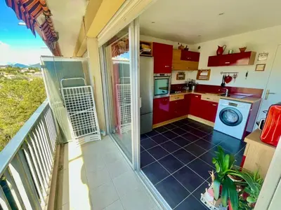 a kitchen with red cabinets and a balcony at Beautiful 3-room apartment with terrace in Nice