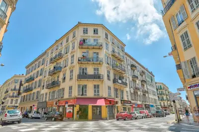 a tall yellow building with cars parked on a street at Magnifique studio en plein centre de Nice in Nice