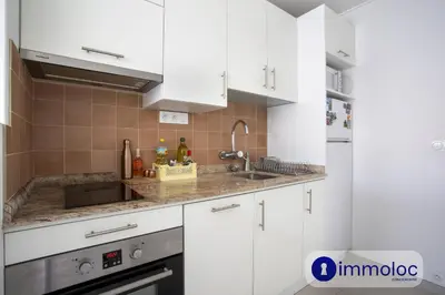 a kitchen with white cabinets and a sink at Studio near airport in Nice