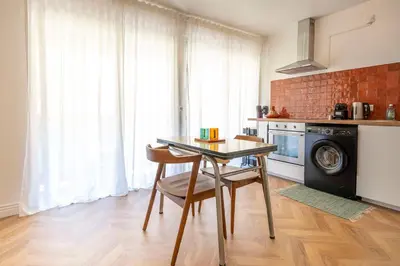 a kitchen with a table and chairs in a room at Superbe 2 pièces contemporain au cœur de Nice in Nice