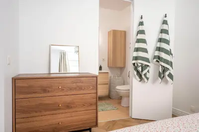 a bedroom with a dresser and a bathroom with a toilet at Superbe 2 pièces contemporain au cœur de Nice in Nice