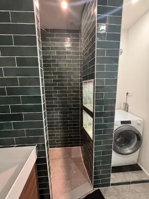 a washer and dryer in a bathroom with green tiles at Beautiful 2-room, AC, Center, terrace in Nice