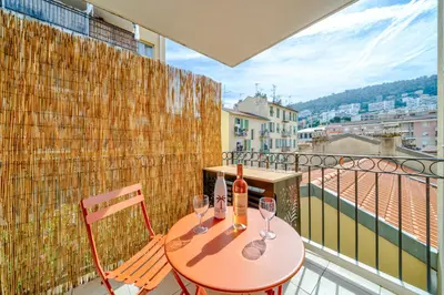 a table with two wine glasses on a balcony at Studio port de Nice Clim Balcon in Nice