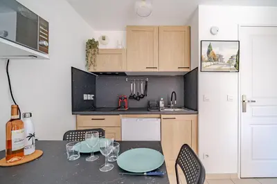 a kitchen with a table and chairs and a counter top at Studio port de Nice Clim Balcon in Nice