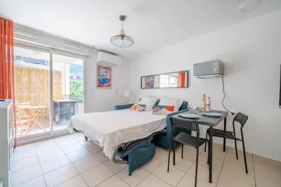 a bedroom with a bed and a table and a desk at Studio port de Nice Clim Balcon in Nice