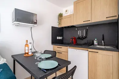 a small kitchen with a table with wine glasses on it at Studio port de Nice Clim Balcon in Nice