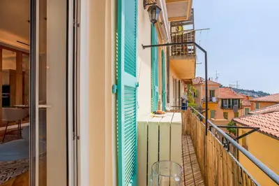 a balcony with blue and green shutters on a building at BAY VIEW AP4470 By Riviera Holiday Homes in Villefranche-sur-Mer