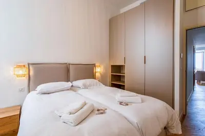 a bedroom with a large white bed with towels on it at BAY VIEW AP4470 By Riviera Holiday Homes in Villefranche-sur-Mer