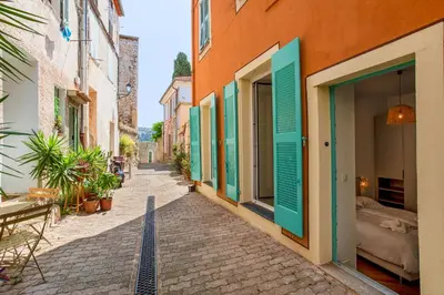 a street in an old town with green shutters at BAY VIEW AP4470 By Riviera Holiday Homes in Villefranche-sur-Mer