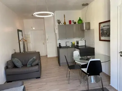 a kitchen and a living room with a table and a couch at Apartment on Dante street next to the sea in Nice