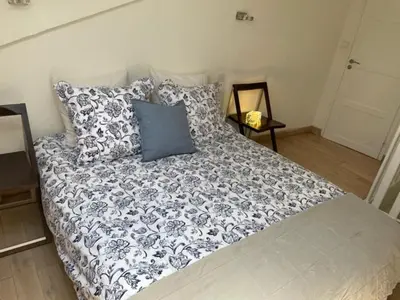 a bed with a blue and white blanket and pillows at Apartment on Dante street next to the sea in Nice