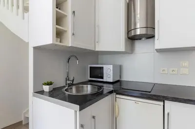 a kitchen with white cabinets and a sink and a microwave at Apartment on Dante street next to the sea in Nice